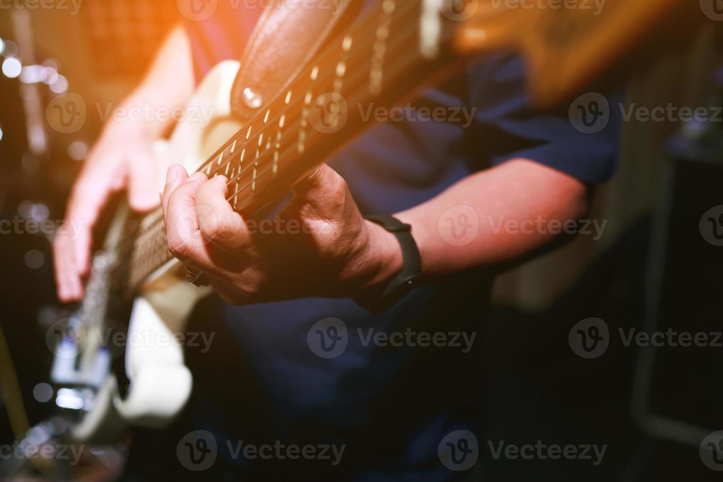 close up hand young man playing electric guitar at recording studio rehearsal base. rock music band. photo