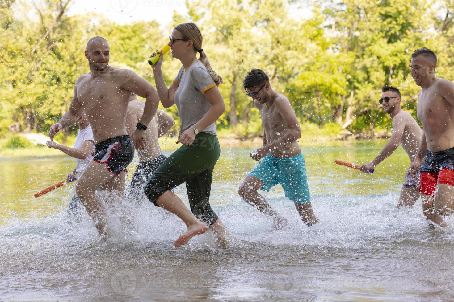 grupo de amigos felices divirtiéndose en el río foto