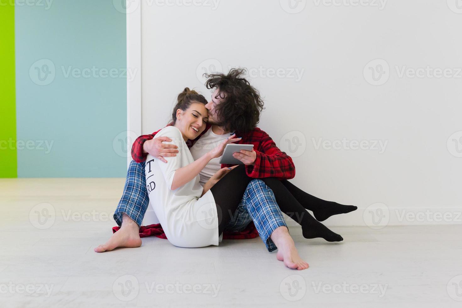 Young Couple using digital tablet on the floor photo