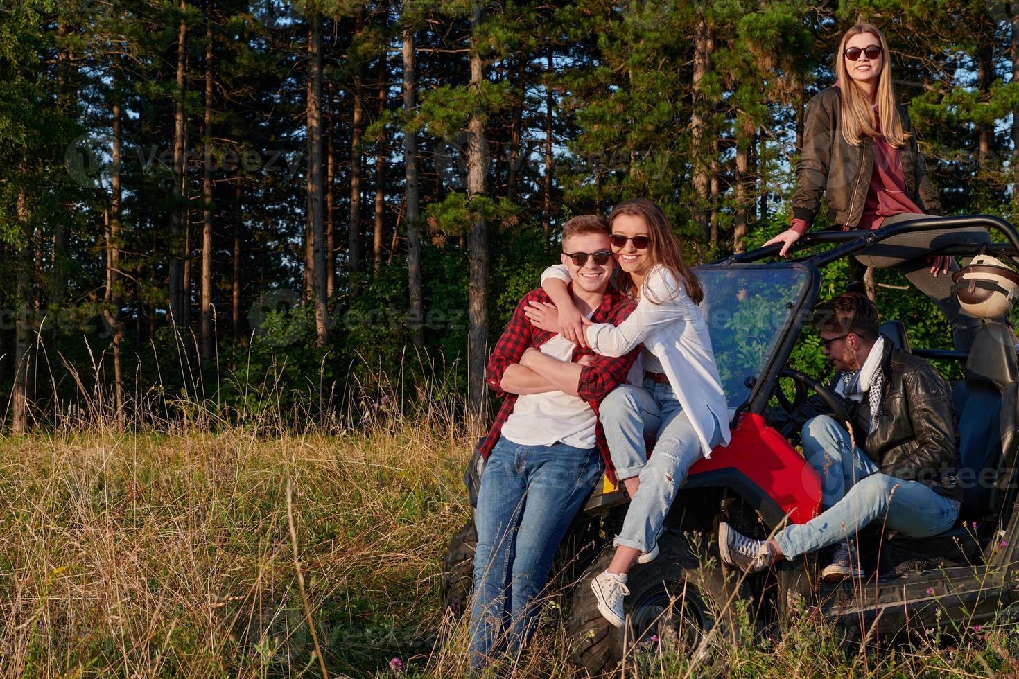 group young happy people enjoying beautiful sunny day while driving a off road buggy car photo