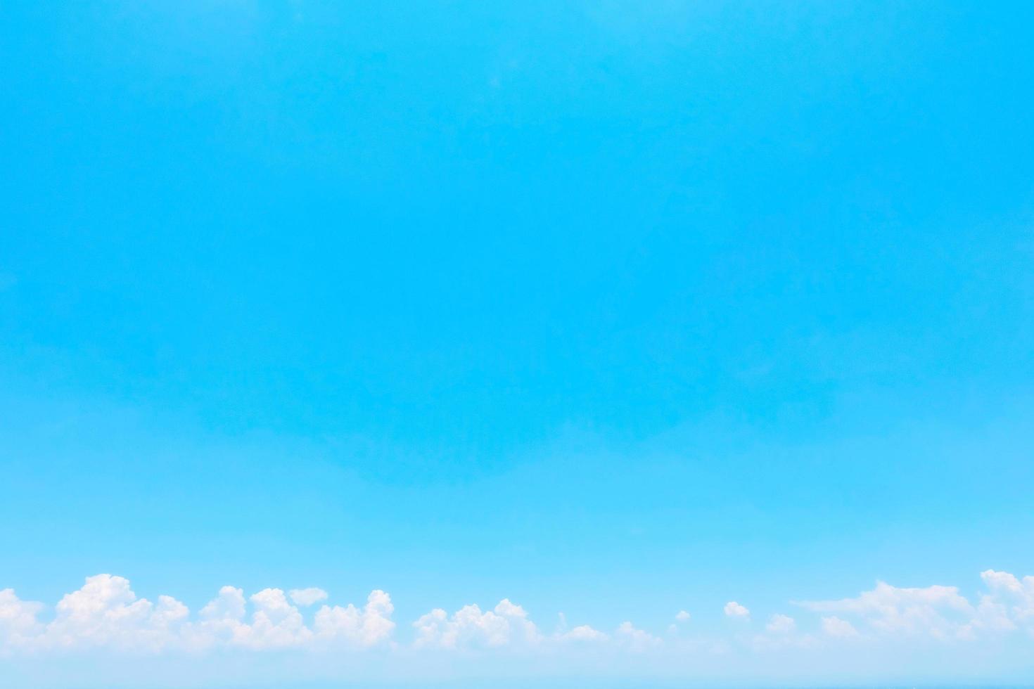 Clear sky background,  with clouds floating at the bottom of the image. photo