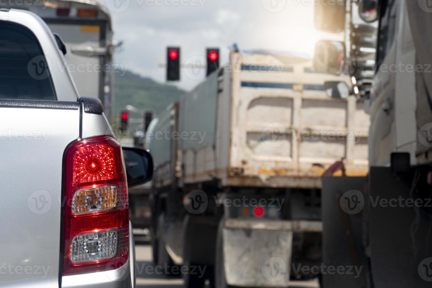 parte trasera del camión plateado de recogida en la carretera que se dirige hacia la meta del viaje. viajando por trabajo durante la hora pico. Entorno de parada de camiones de muchas ruedas en el cruce por control de luz roja. foto