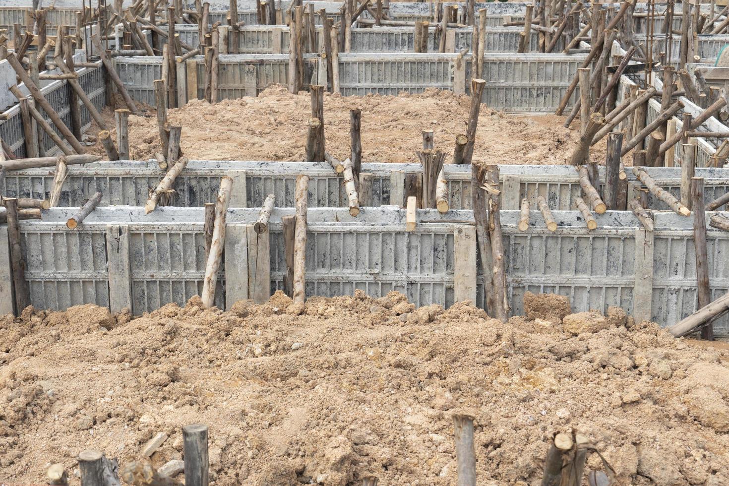 Block formwork for house beams with supported by wooden logs. Construction of the foundation of the house on the ground during the day time. photo