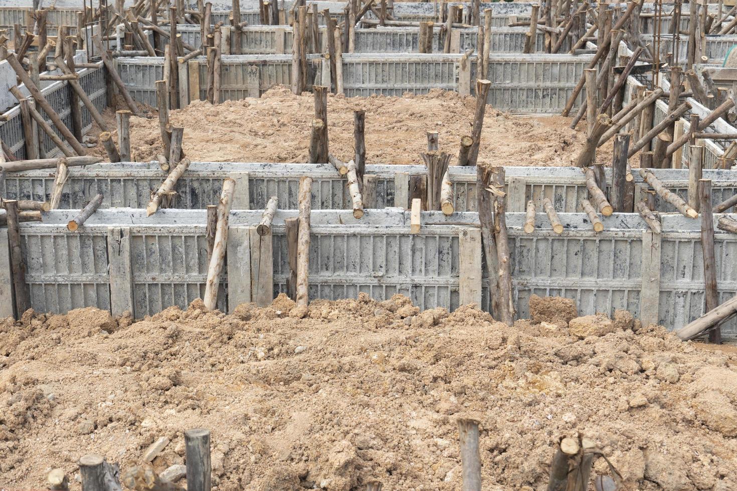 Block formwork for house beams with supported by wooden logs. Construction of the foundation of the house on the ground during the day time. photo