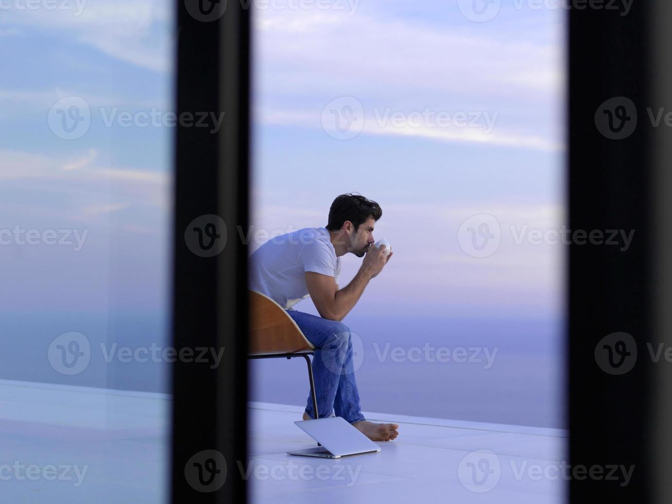 relaxed young man at home on balcony photo