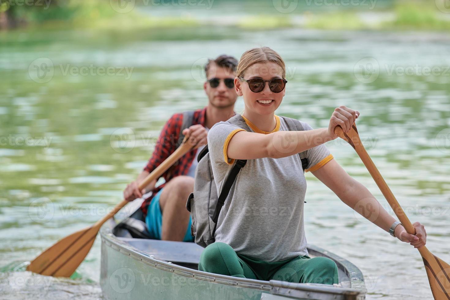friends are canoeing in a wild river photo