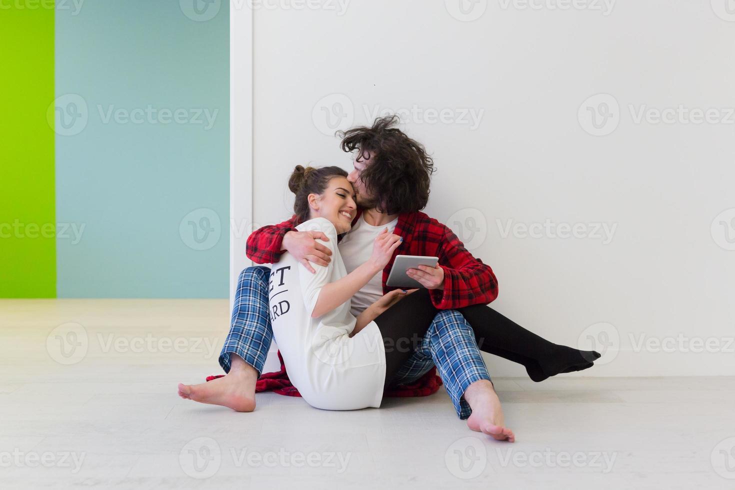 Young Couple using digital tablet on the floor photo