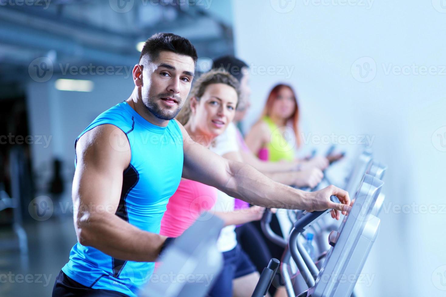 Group of people running on treadmills photo