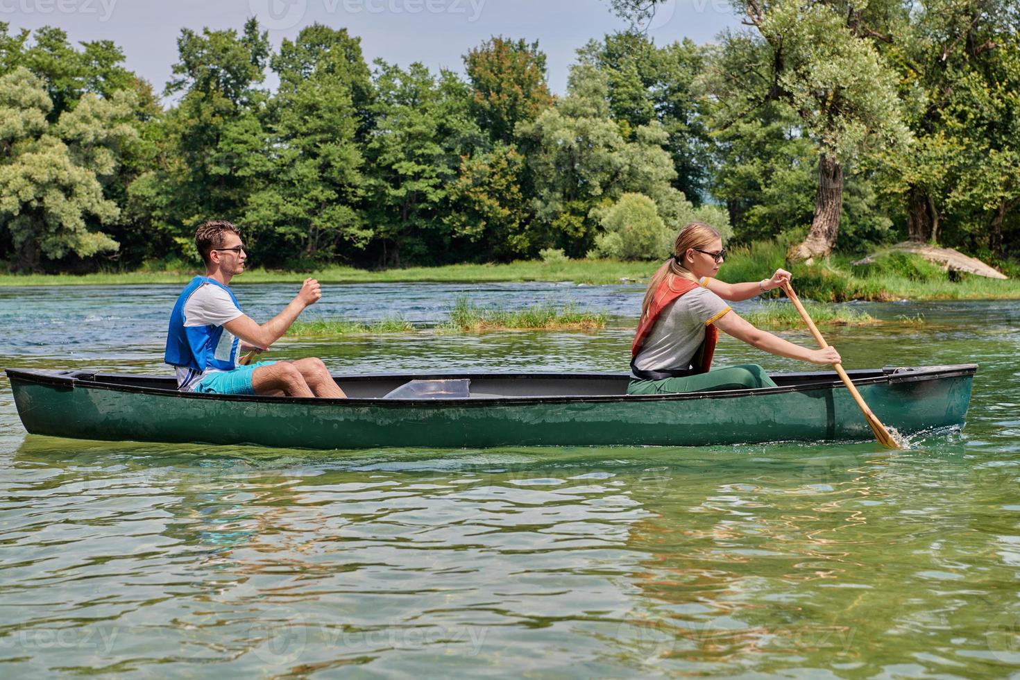 friends are canoeing in a wild river photo