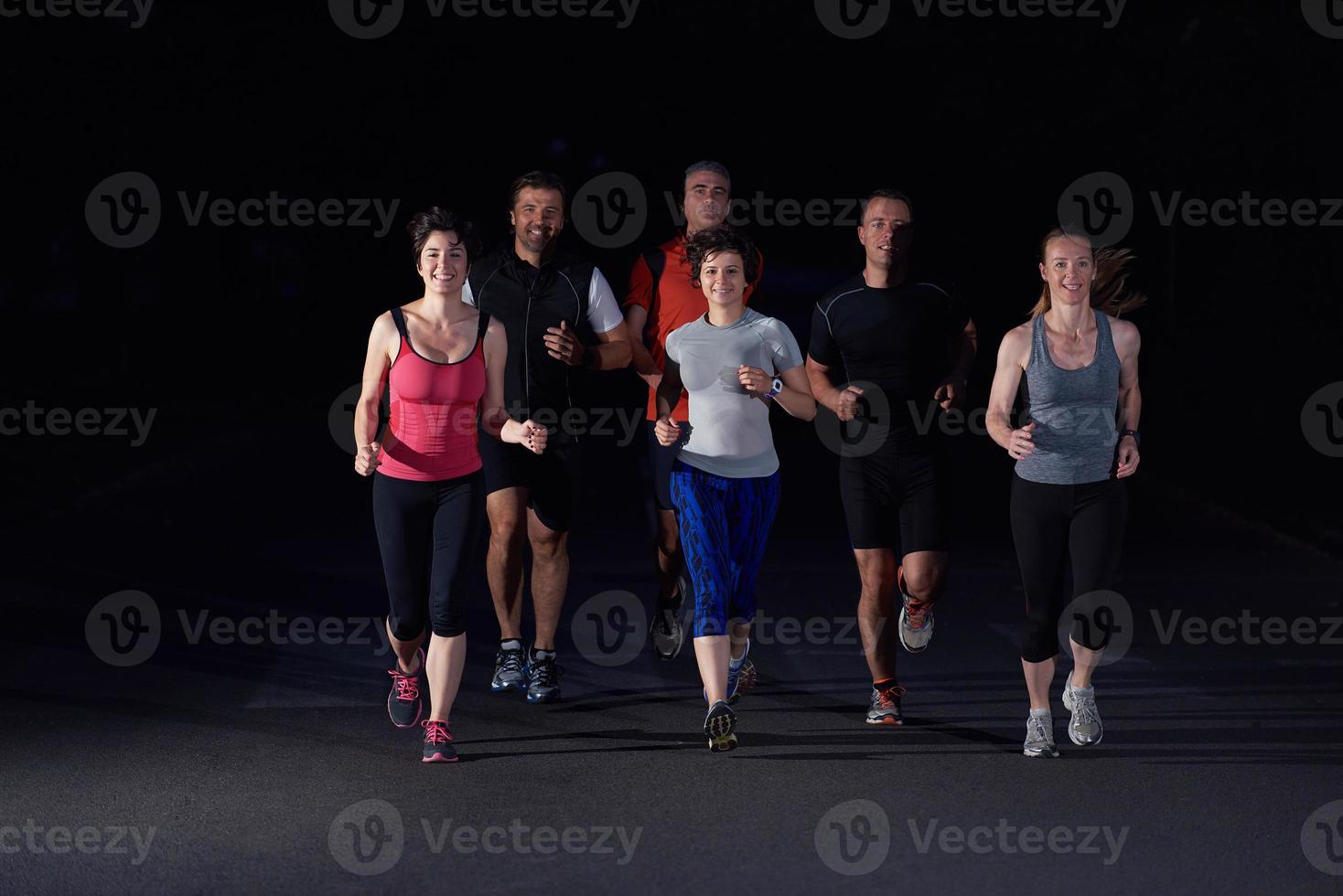 people group jogging at night photo