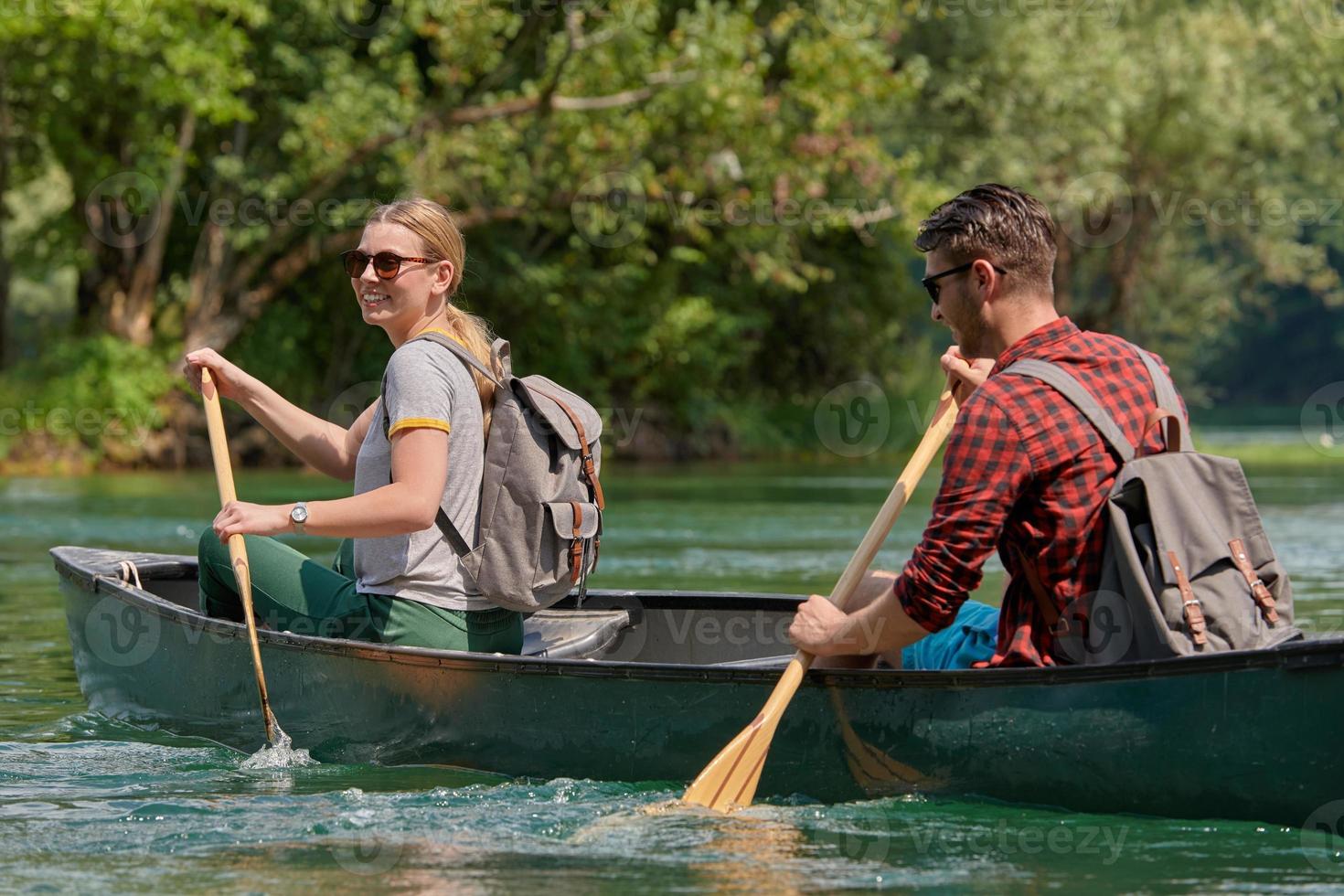 friends are canoeing in a wild river photo