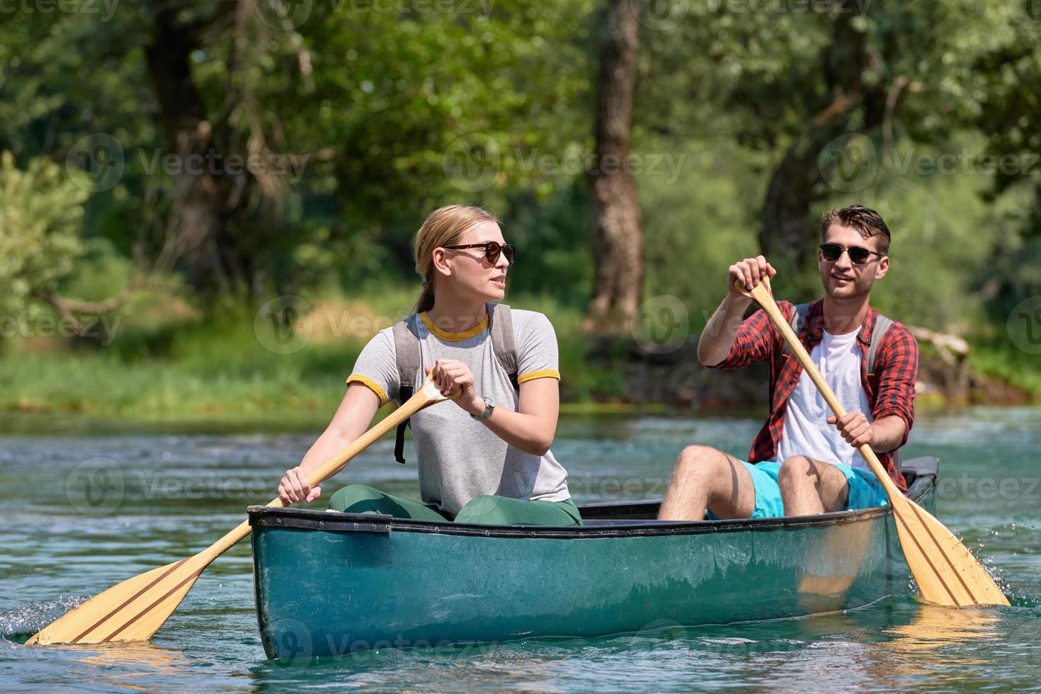 friends are canoeing in a wild river photo