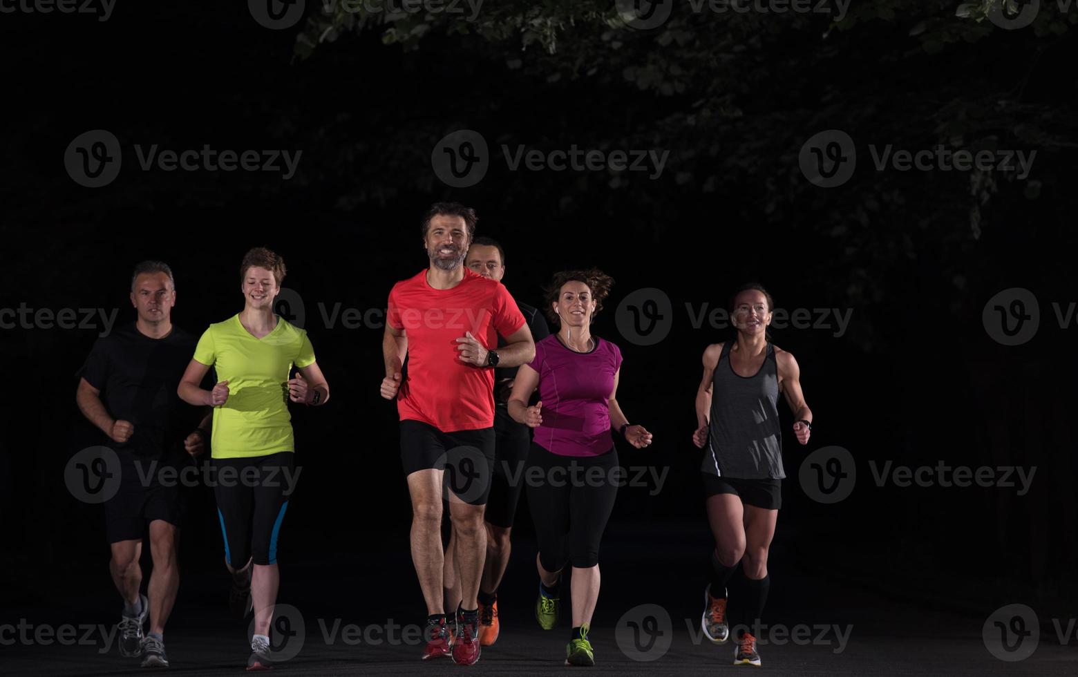 equipo de corredores en el entrenamiento nocturno foto