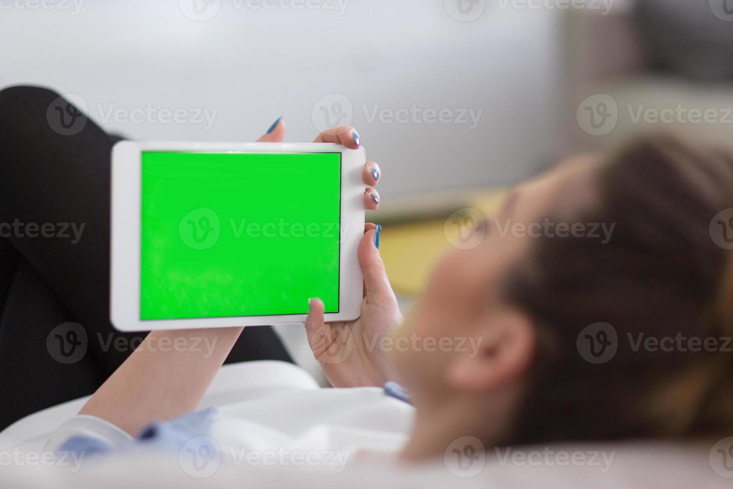 woman on sofa using tablet computer photo