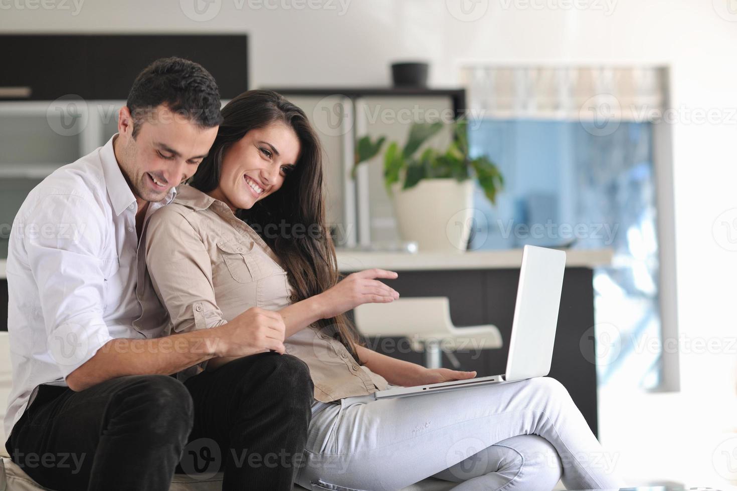 joyful couple relax and work on laptop computer at modern home photo