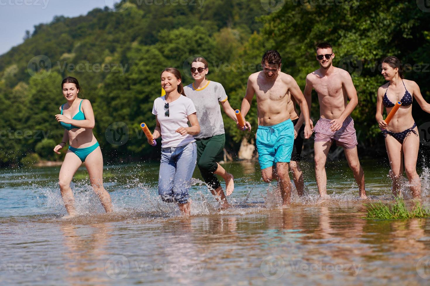 grupo de amigos felices divirtiéndose en el río foto