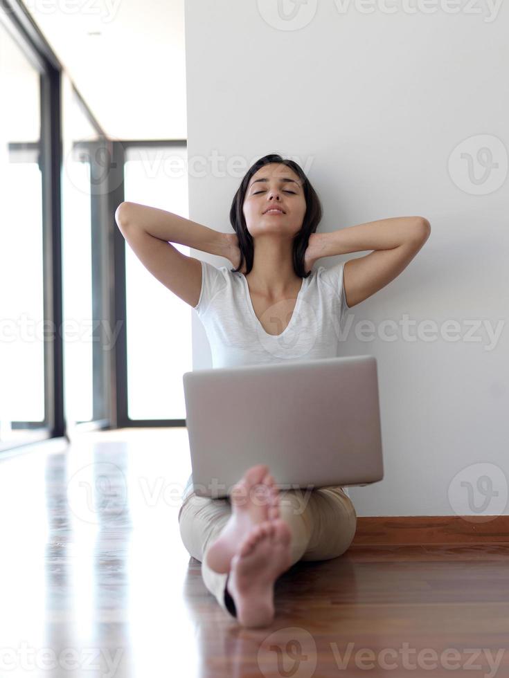 relaxed young woman at home working on laptop computer photo