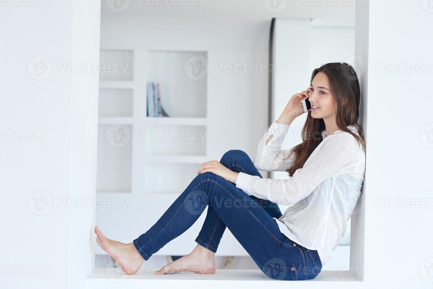 young woman using cellphone at home photo