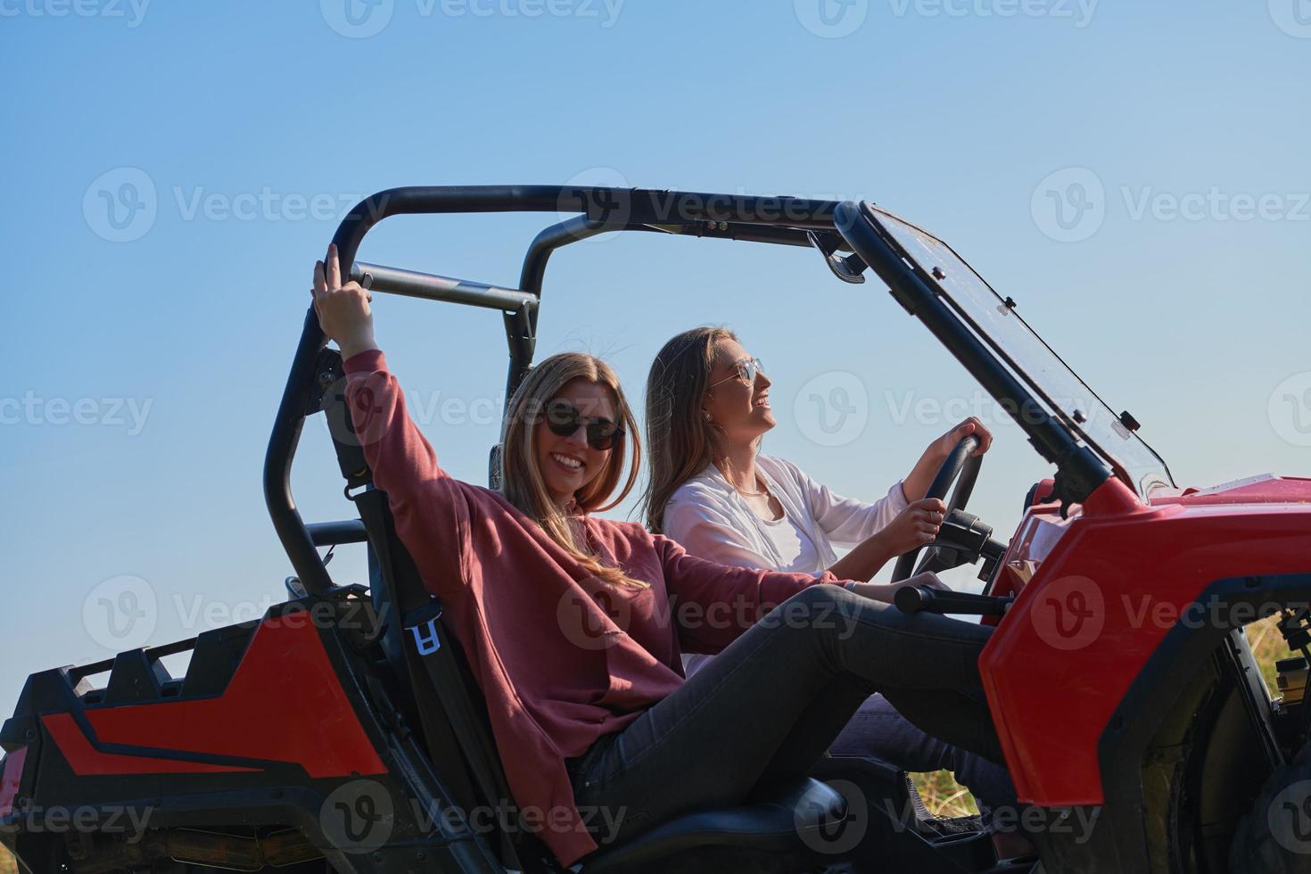 girls enjoying a beautiful sunny day while driving an off-road car photo