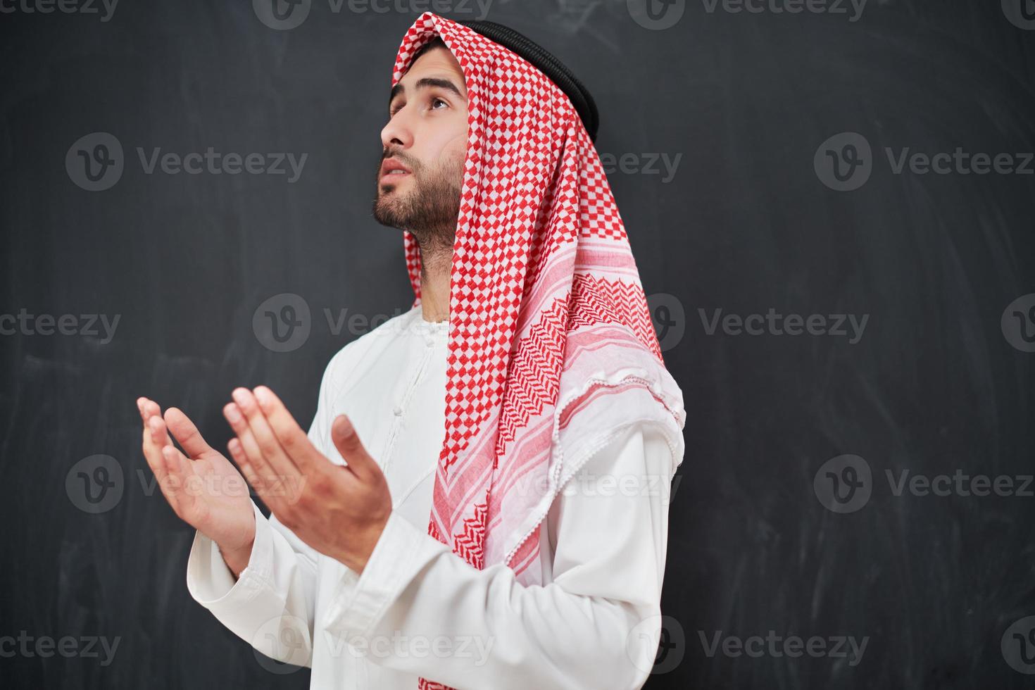 Arab man in traditional clothes praying to God or making dua photo
