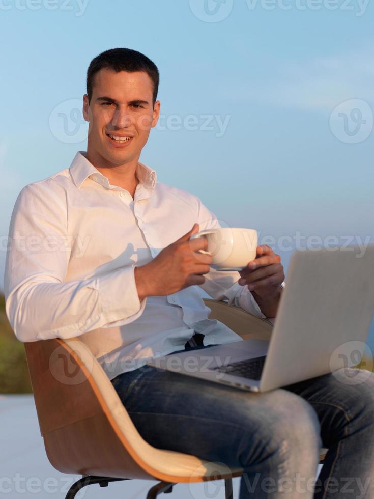 relaxed young man at home on balcony photo
