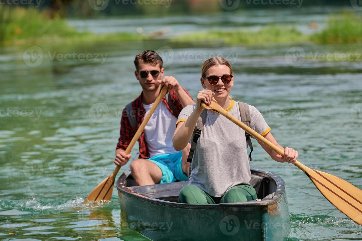 friends are canoeing in a wild river photo