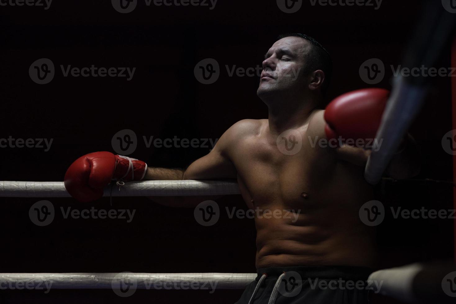 kick boxer descansando sobre las cuerdas en la esquina foto