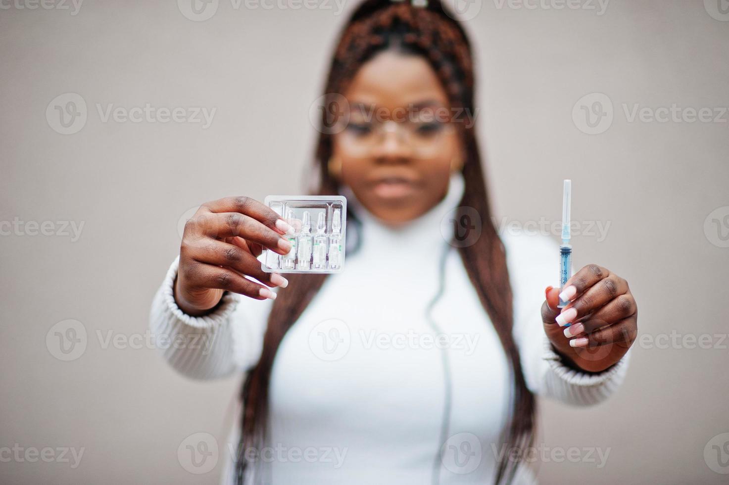 African american woman in eyeglasses hold syringe vaccine. photo