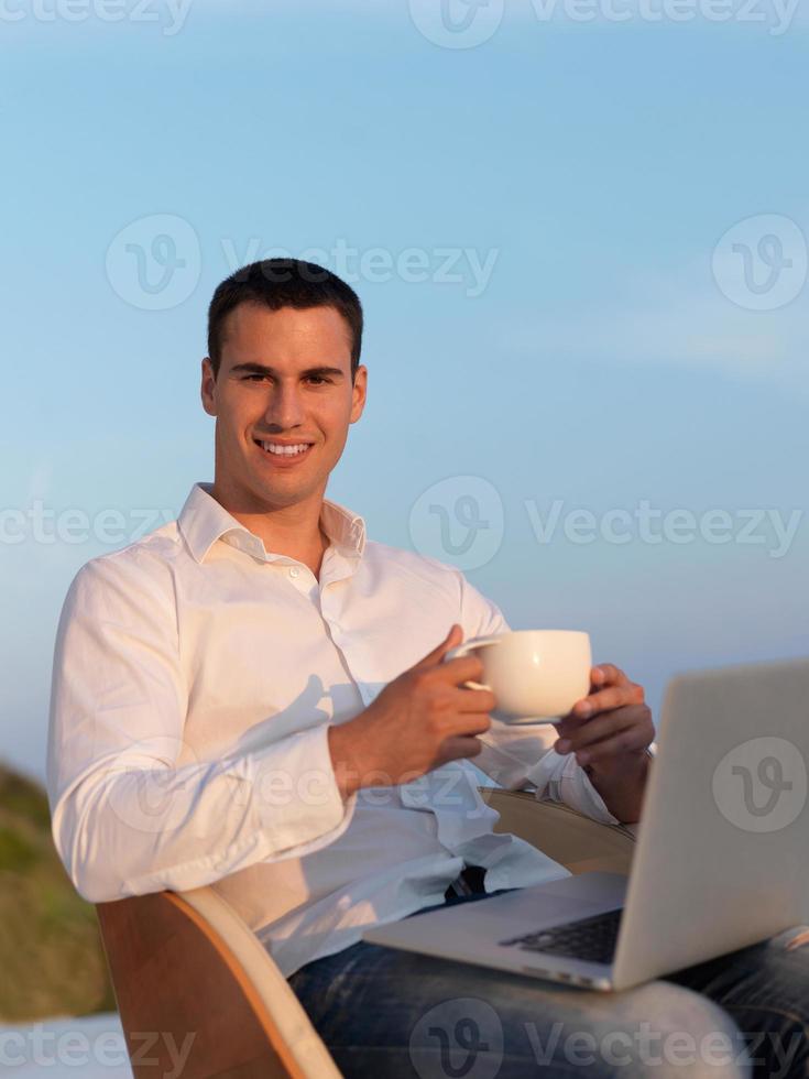 relaxed young man at home on balcony photo