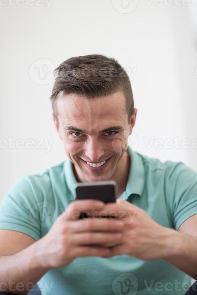 young man using a mobile phone  at home photo