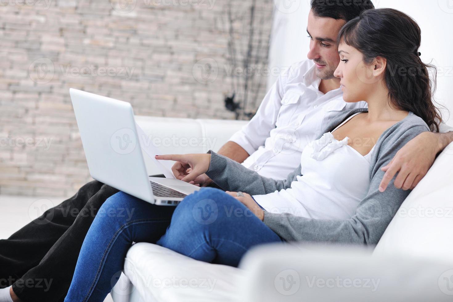 joyful couple relax and work on laptop computer at modern home photo