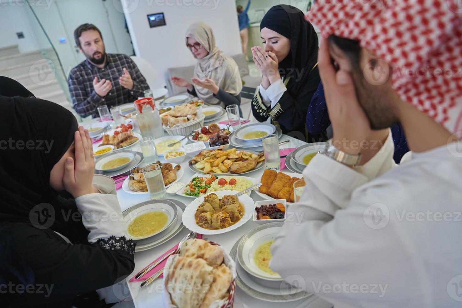 Muslim family making iftar dua to break fasting during Ramadan. photo