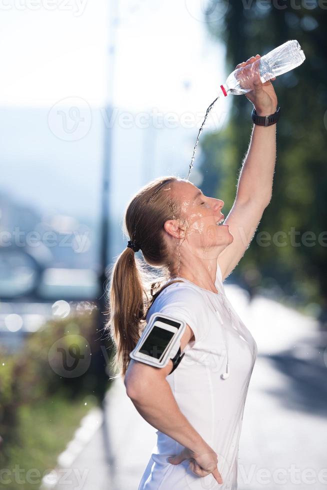 woman drinking  water after  jogging photo