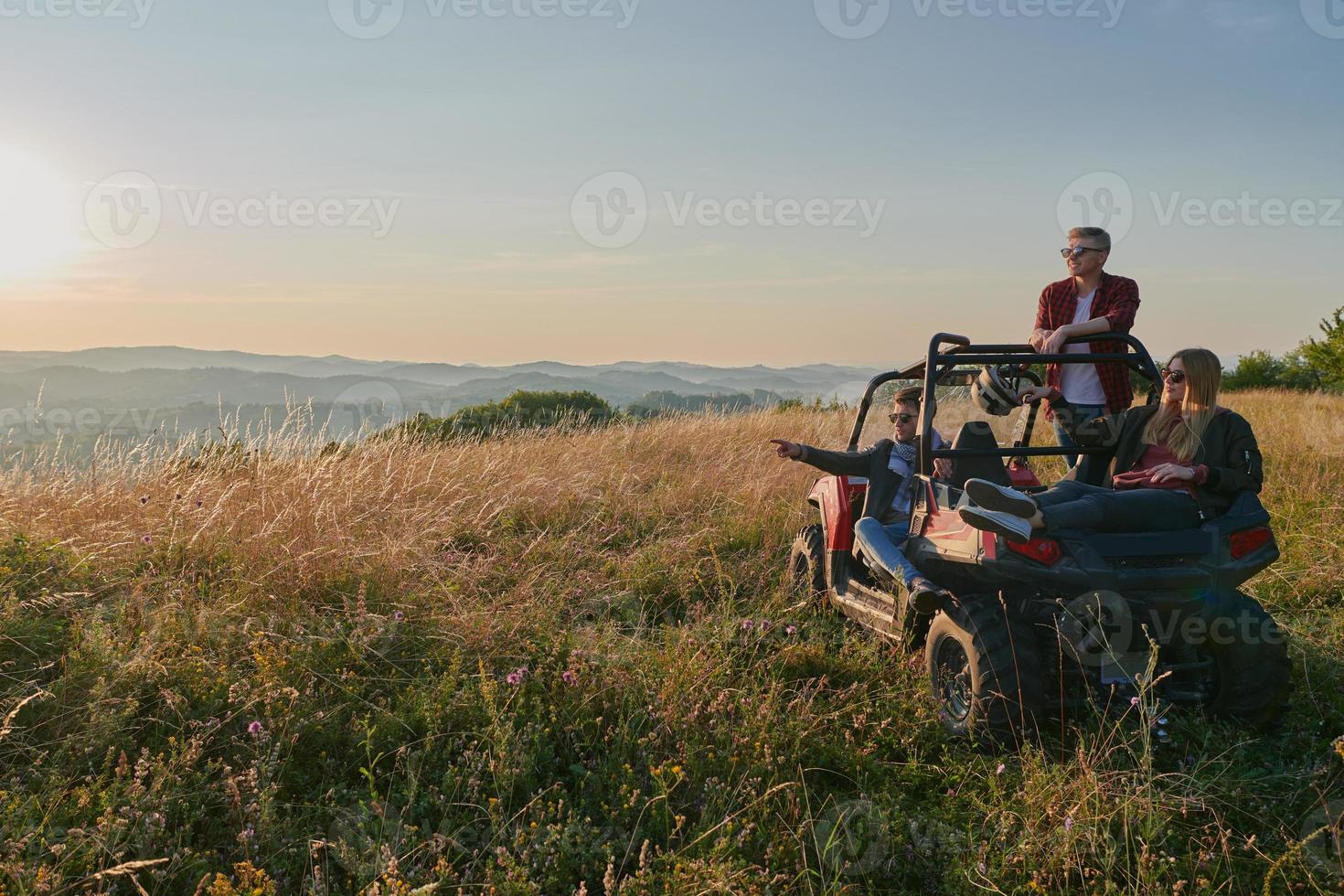 group young happy people enjoying beautiful sunny day while driving a off road buggy car photo
