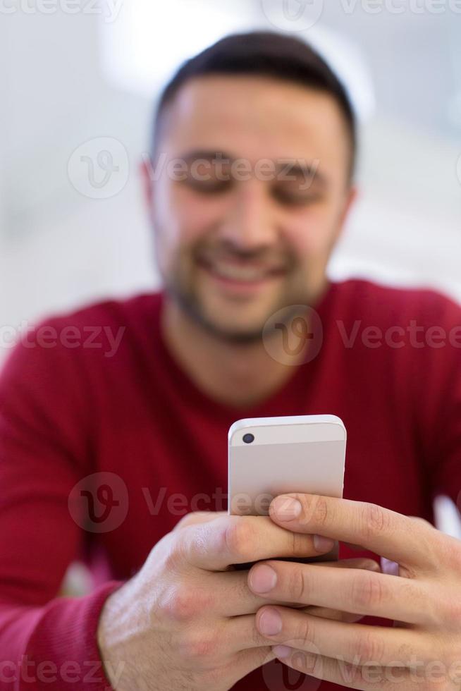 young man using a mobile phone  at home photo