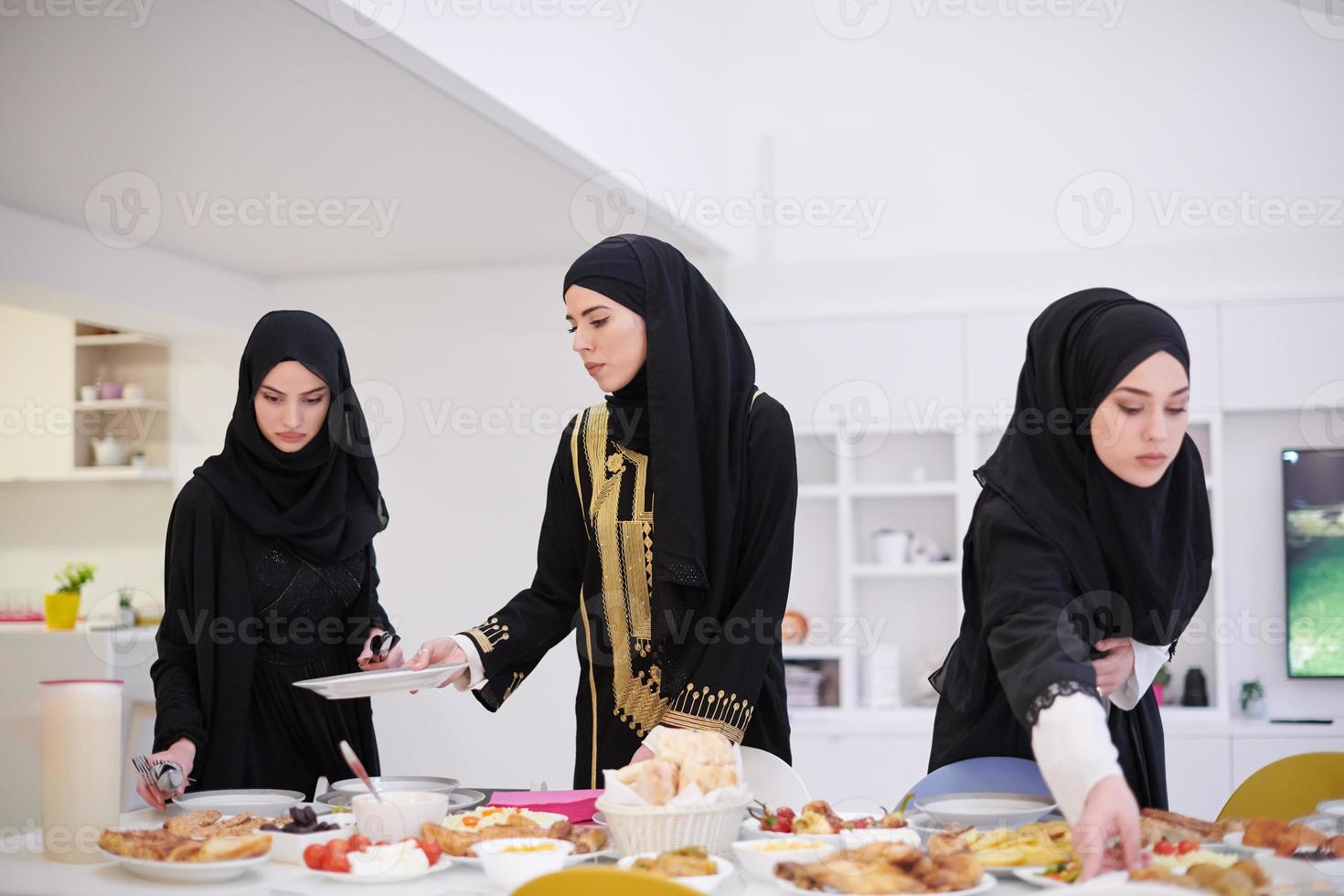 young muslim girls serving food on the table for iftar dinner photo