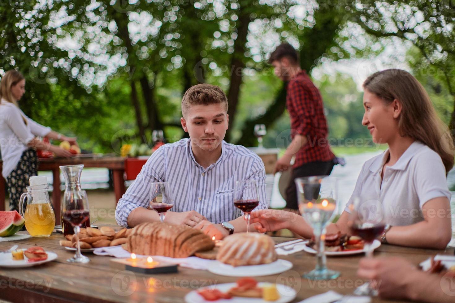 friends having picnic french dinner party outdoor during summer holiday