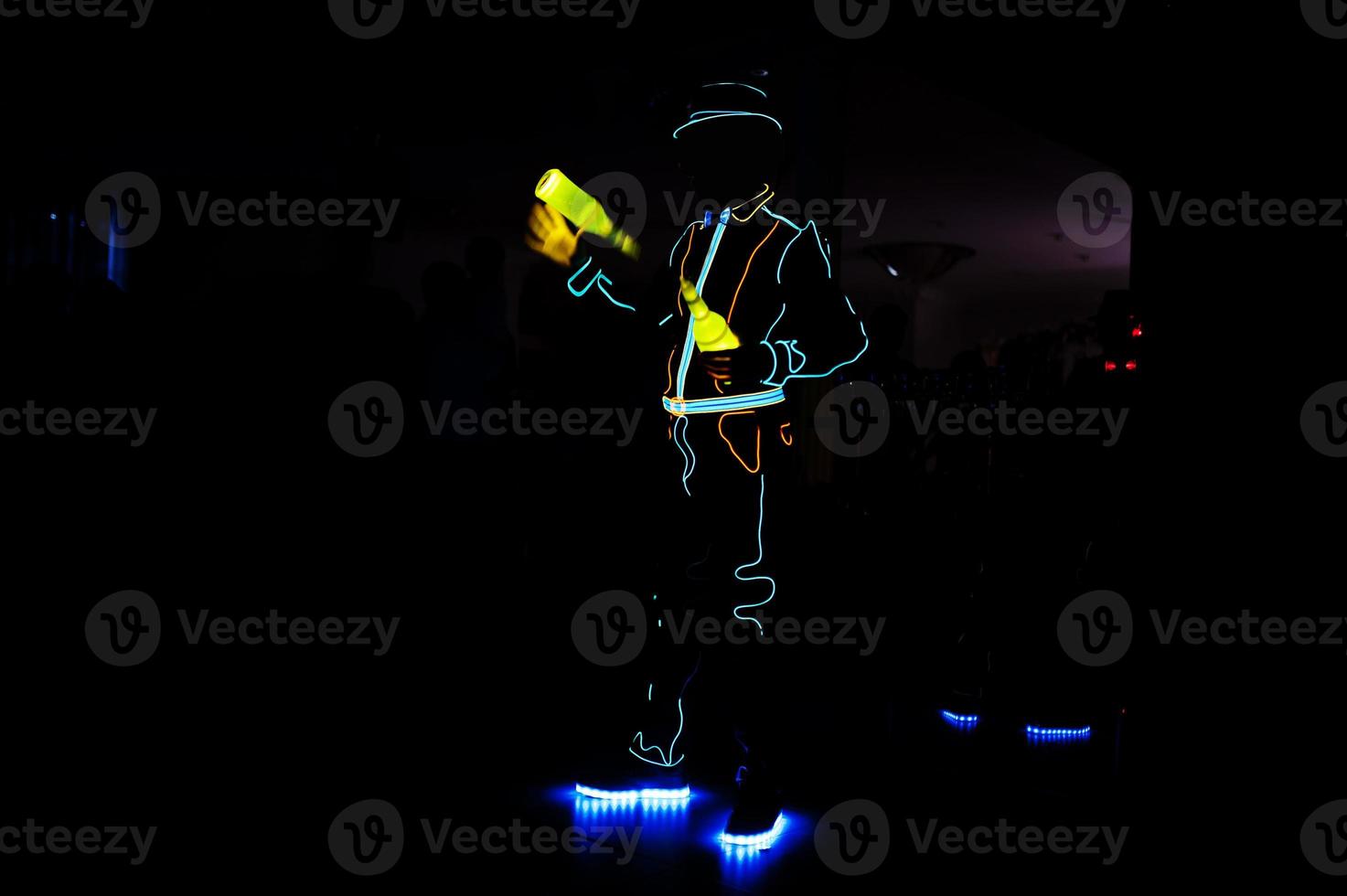 Professional barman and led light show. Silhouette of modern bartender shaking drink at night cocktail bar. photo