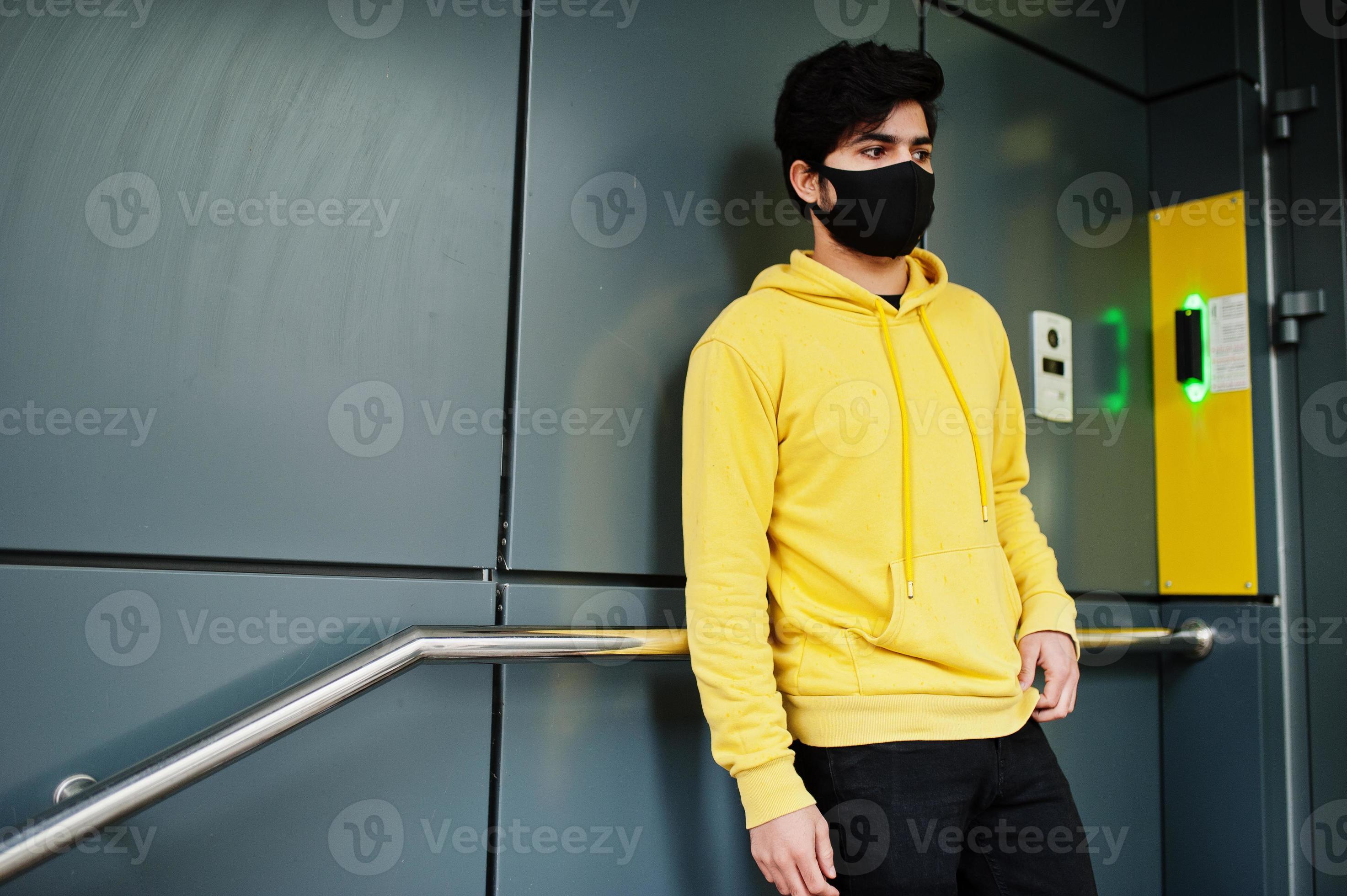 hombre indio joven hipster urbano en una sudadera amarilla de moda