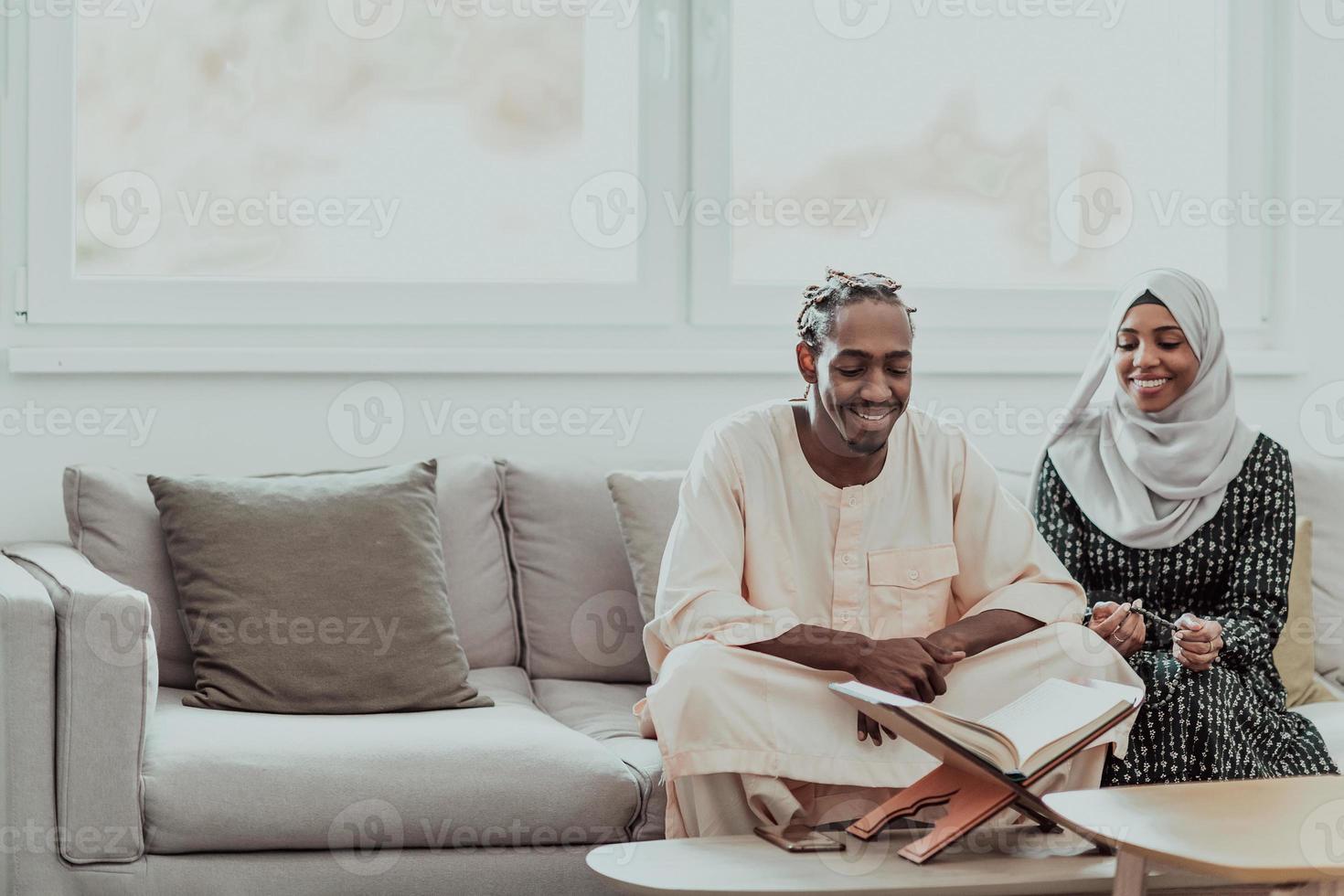 African Muslim couple at home in Ramadan reading Quran holly Islam book. photo