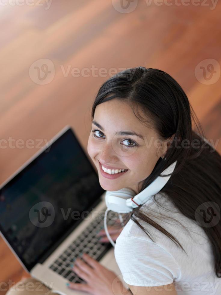 relaxed young woman at home working on laptop computer photo