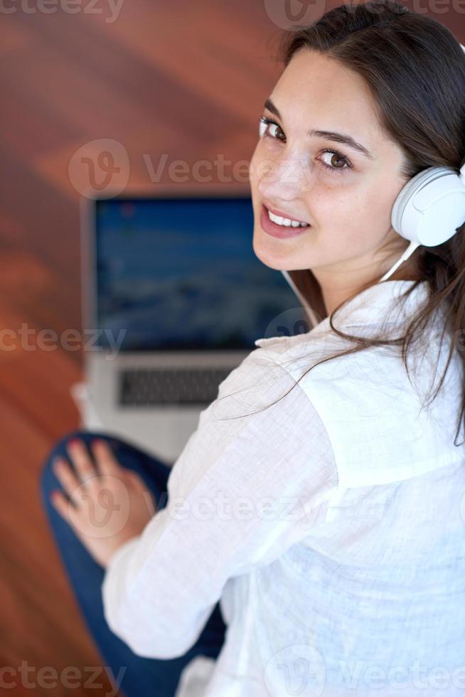 relaxed young woman at home working on laptop computer photo