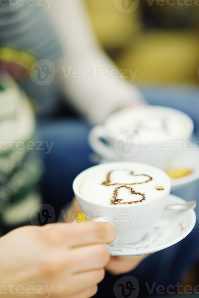 Young romantic couple sitting on sofa in front of fireplace at home photo