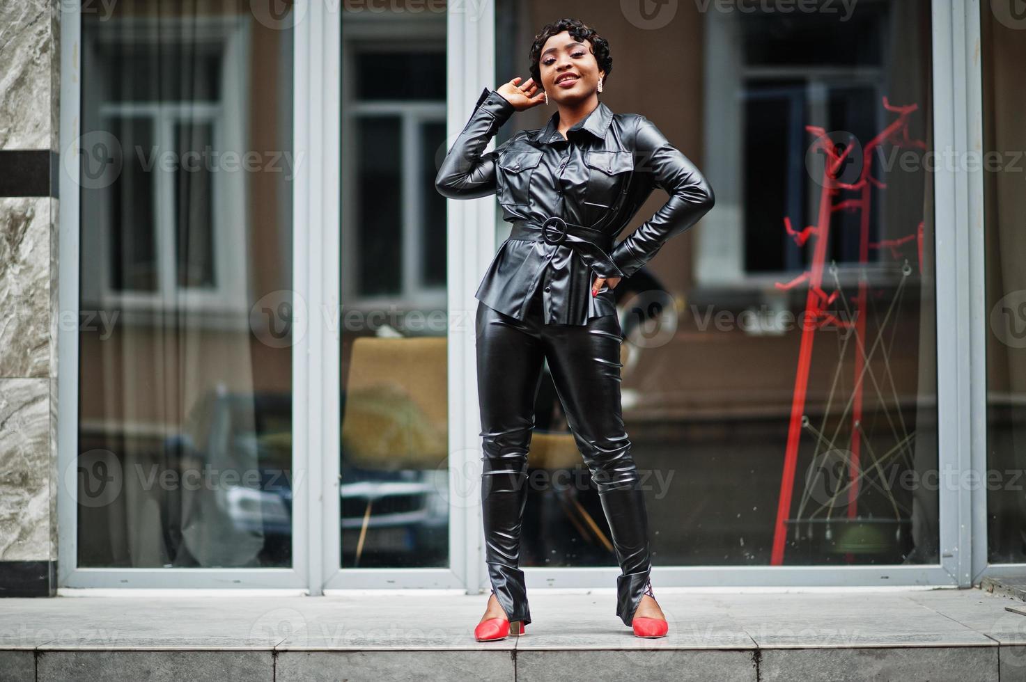 Fashionable beautiful african american woman posing in black leather jacket  and pants at street. 11011679 Stock Photo at Vecteezy