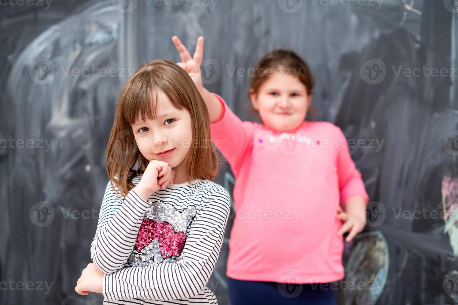 little girls having fun in front of chalkboard photo