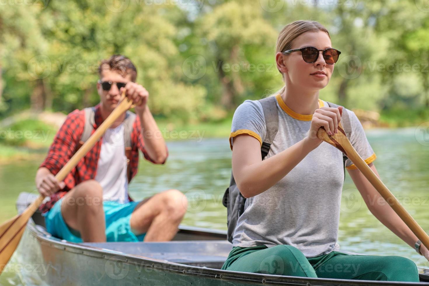 friends are canoeing in a wild river photo