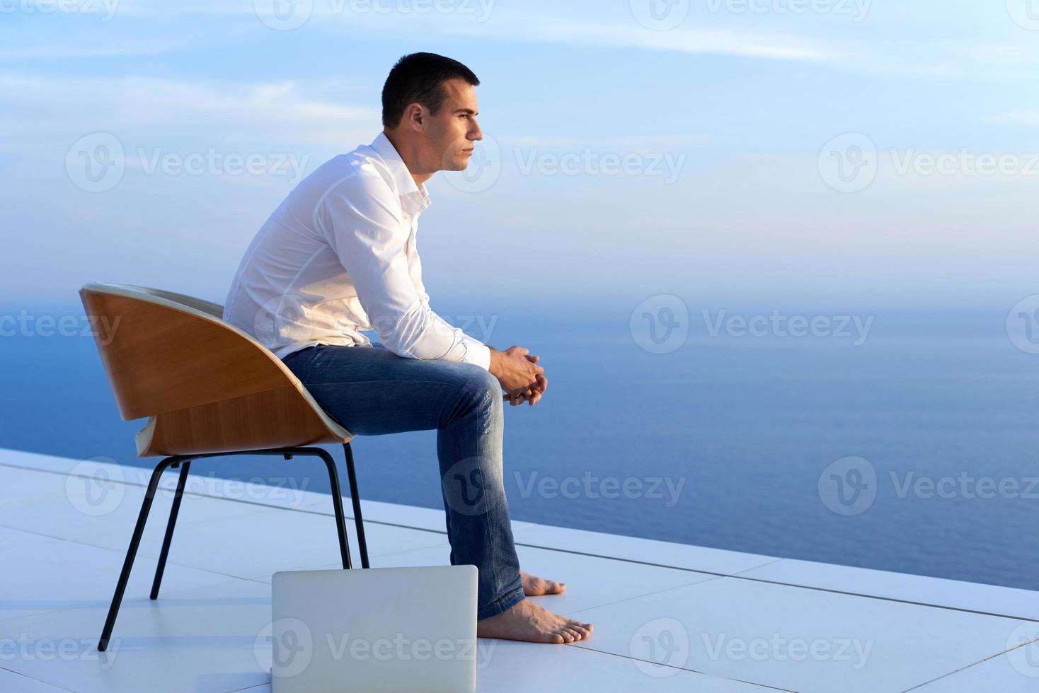 relaxed young man at home on balcony photo