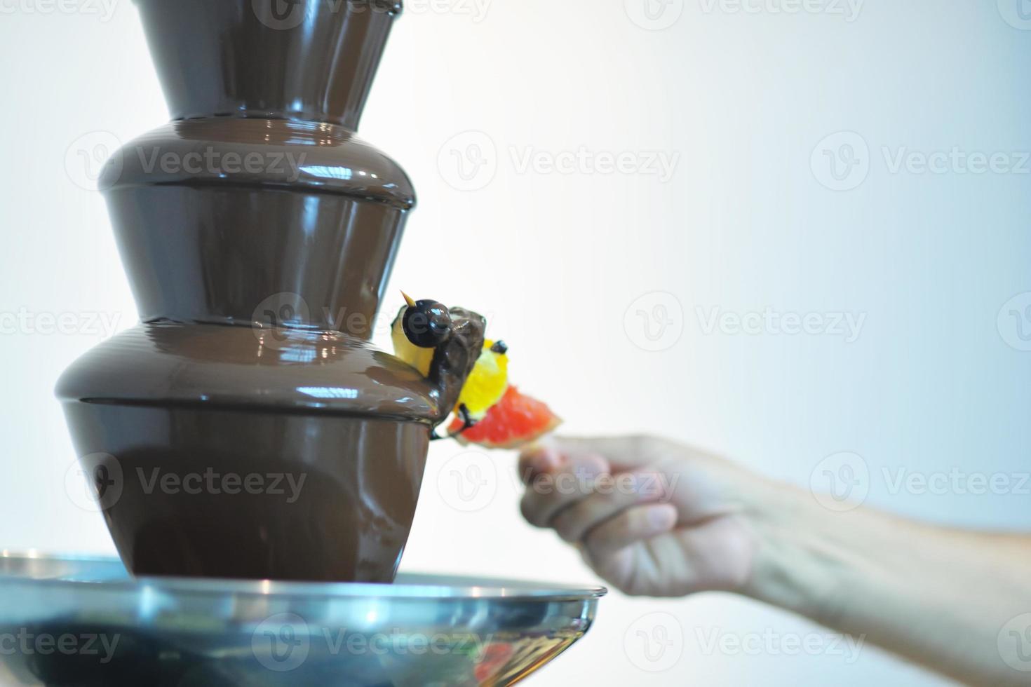 liquid chocolate fountain and fresh fruits on stick photo