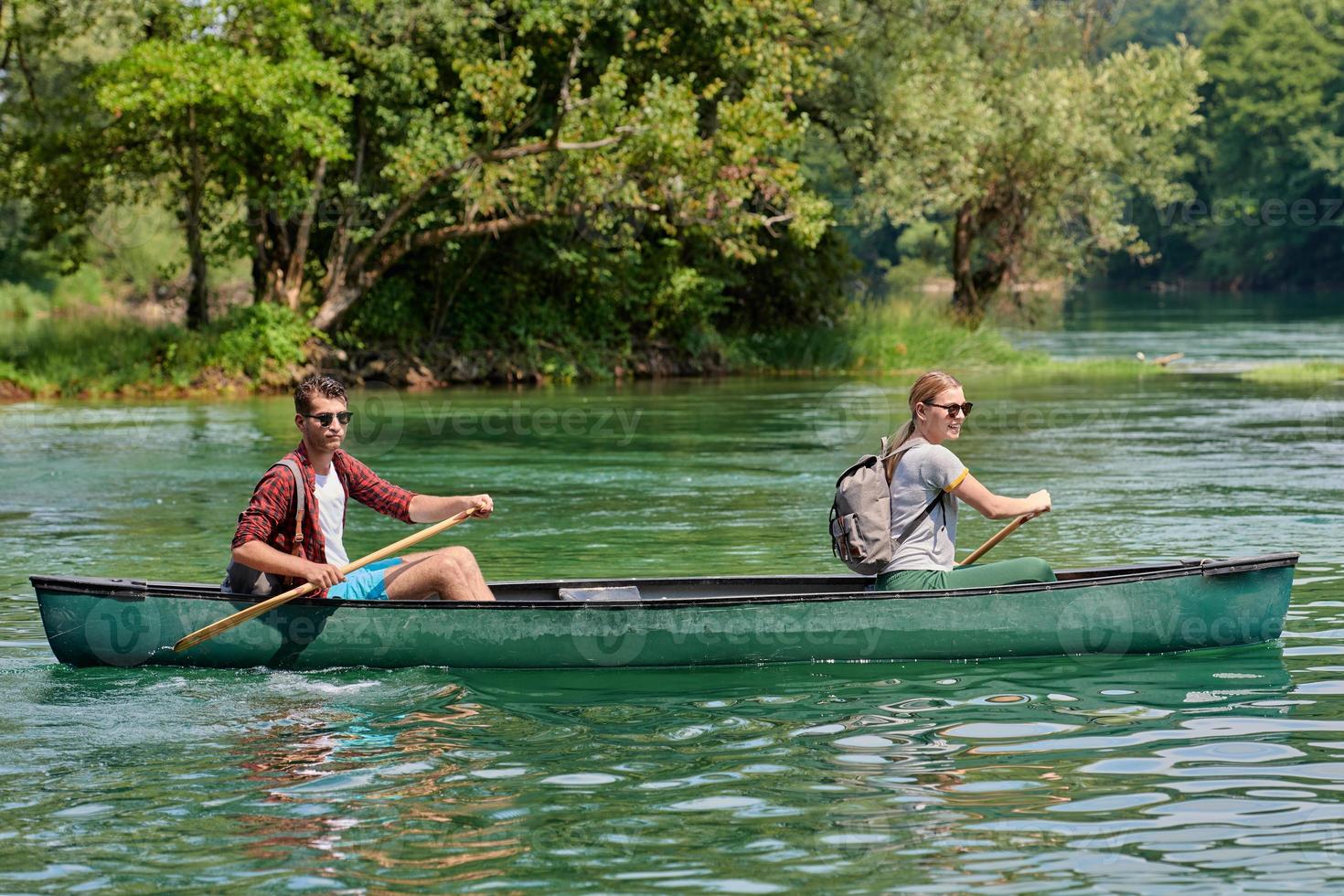 friends are canoeing in a wild river photo