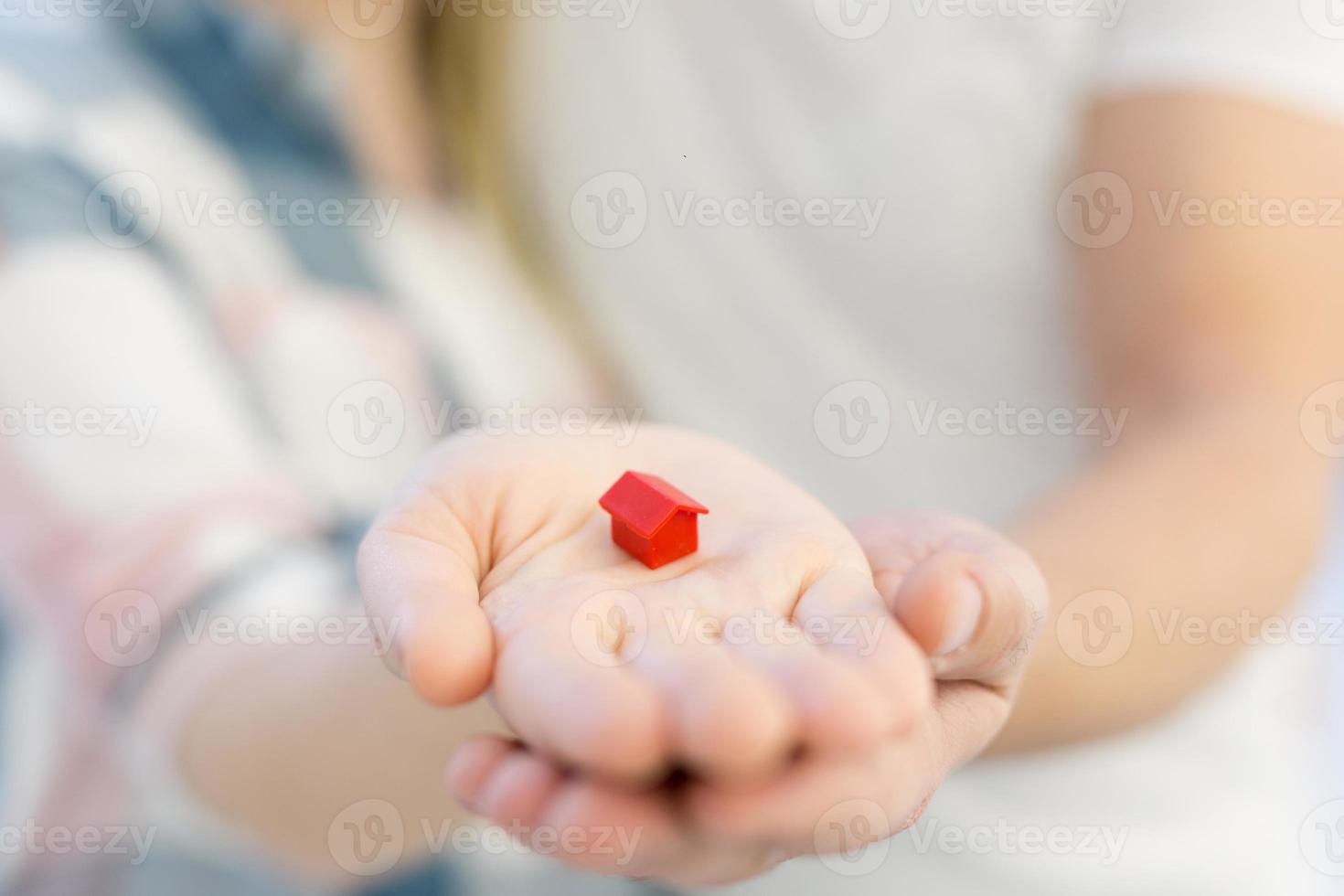 couple showing small red house in hands photo